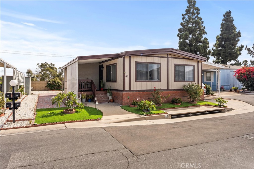 a front view of a house with a yard and potted plants