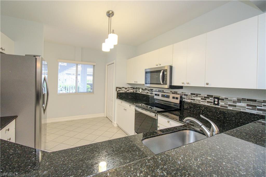 a kitchen with granite countertop a sink stainless steel appliances and cabinets