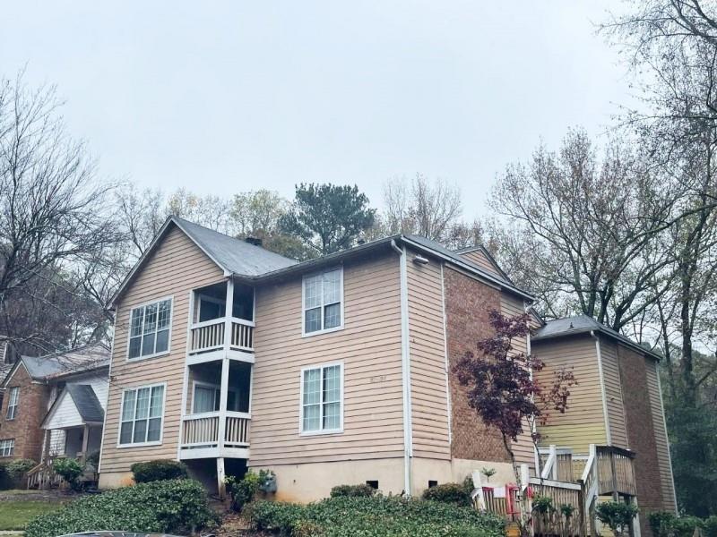 a front view of a house with a yard and trees