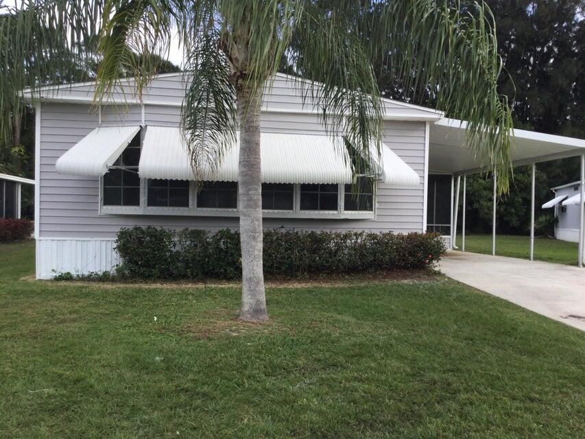 a view of a house with a yard and potted plants