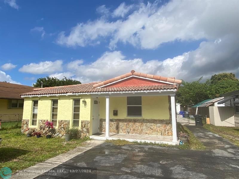 a front view of a house with a garden