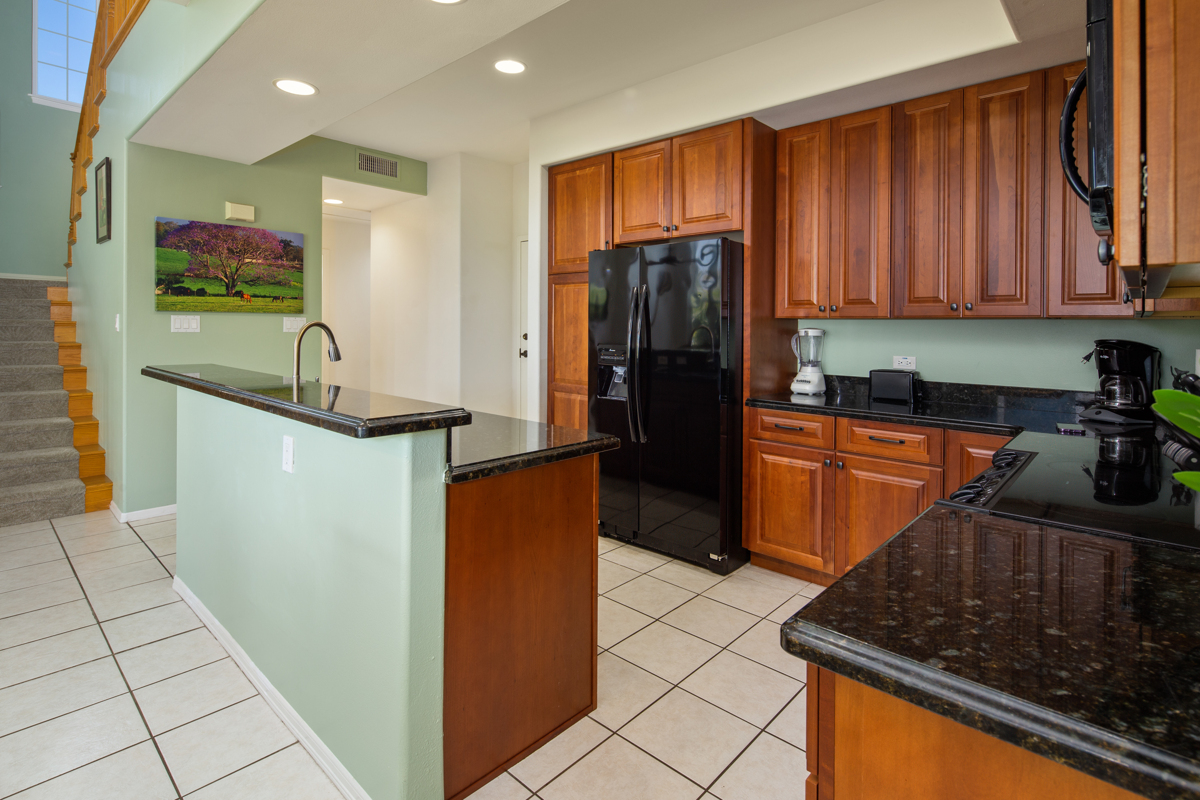 a kitchen with stainless steel appliances granite countertop a refrigerator and a stove top oven