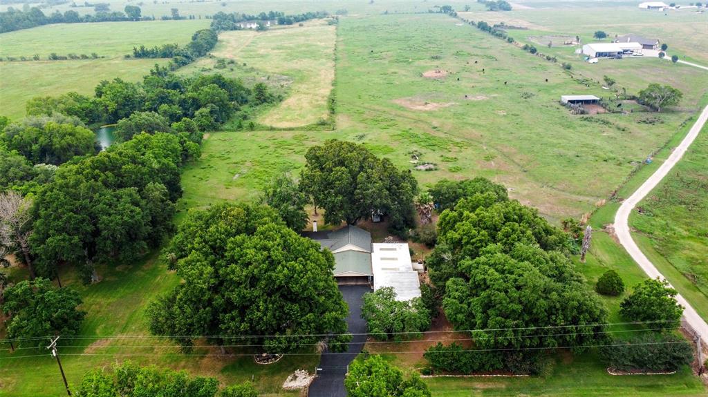 an aerial view of residential houses with outdoor space and trees