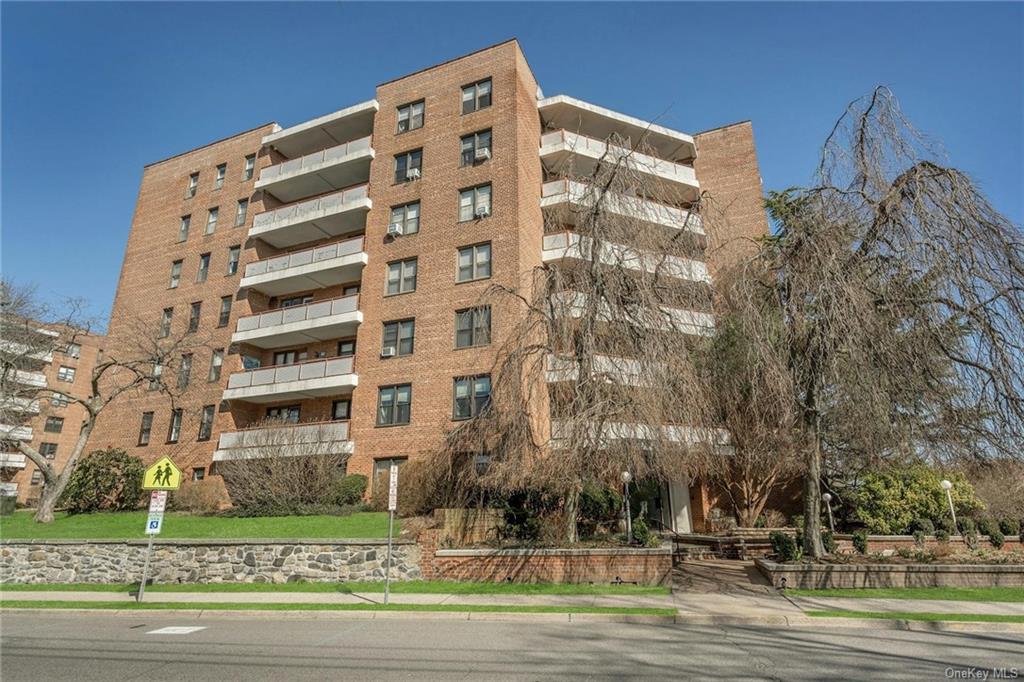 a view of a tall building next to a yard