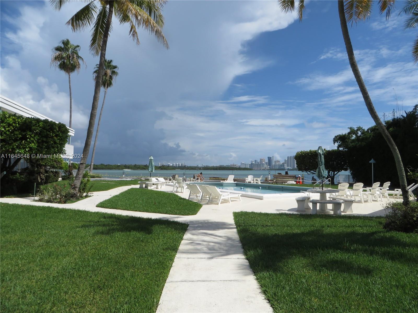 a view of a backyard with couches under an umbrella