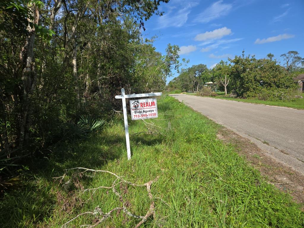 a sign that is sitting in the grass next to a road