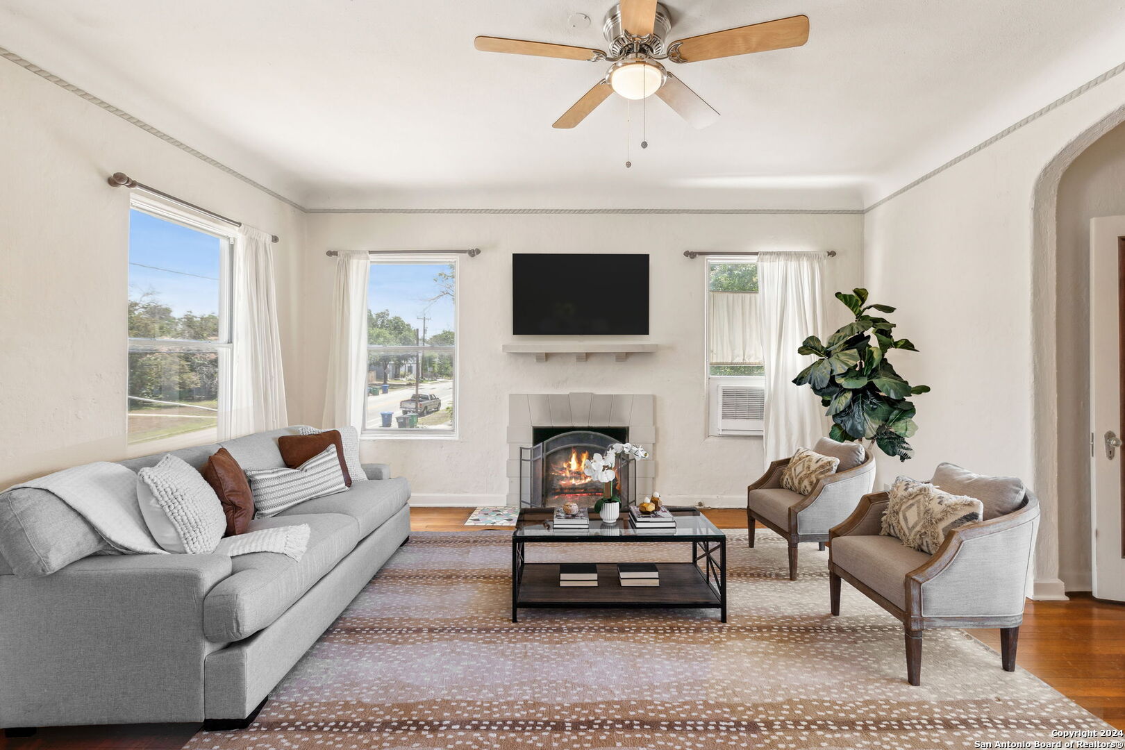 a living room with furniture a fireplace and a flat screen tv