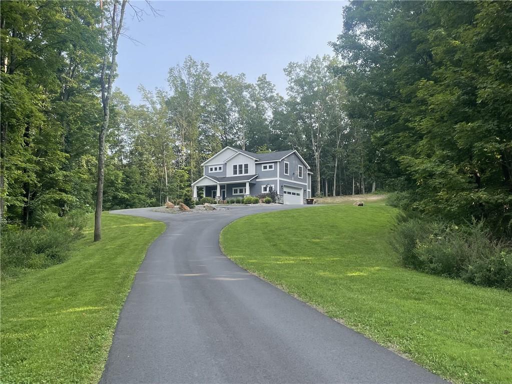 a view of house with garden and tall trees