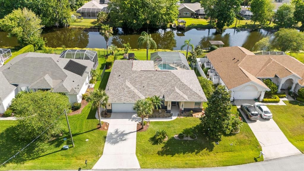 an aerial view of a house with swimming pool and lake view