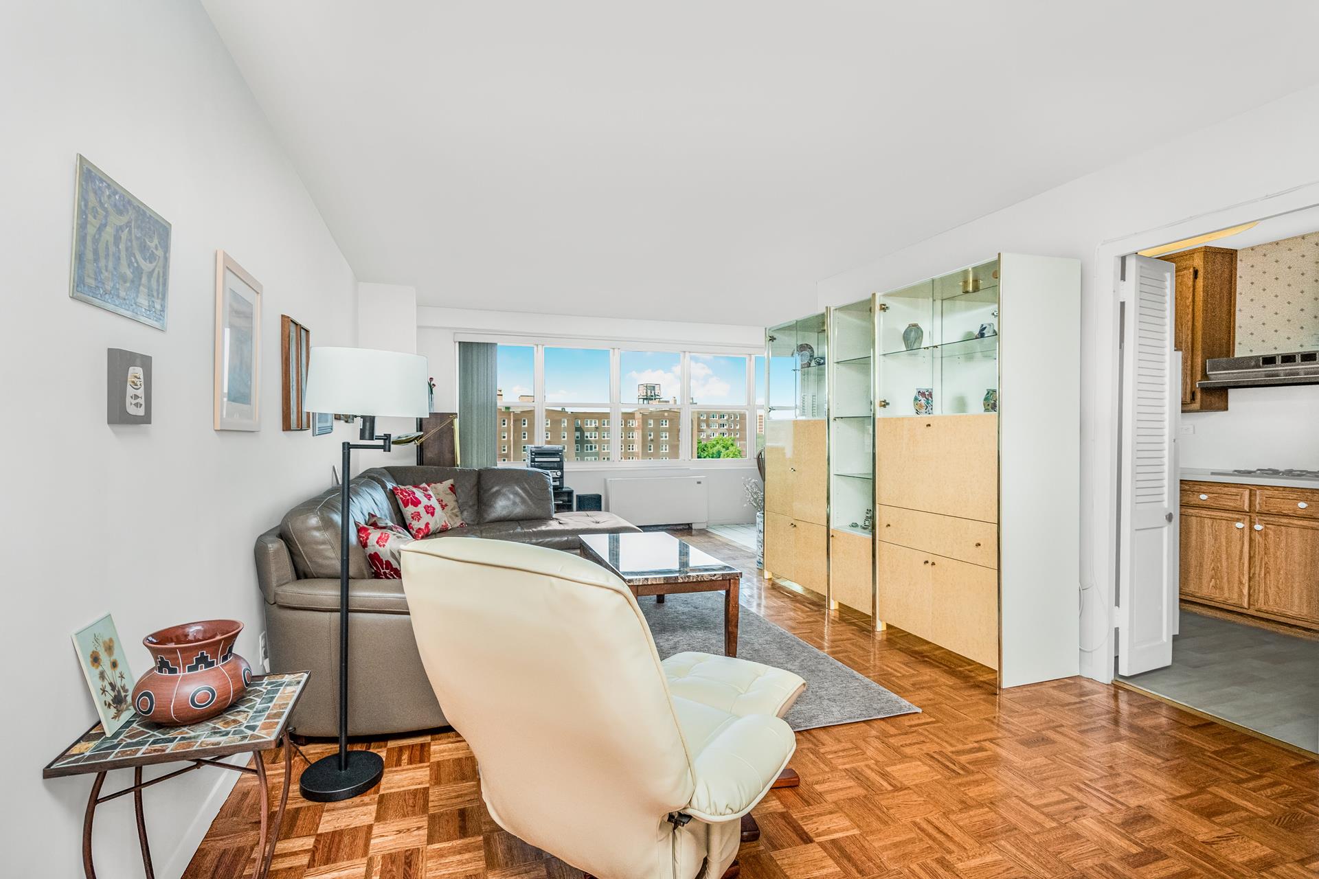 a living room with furniture a flat screen tv and a refrigerator