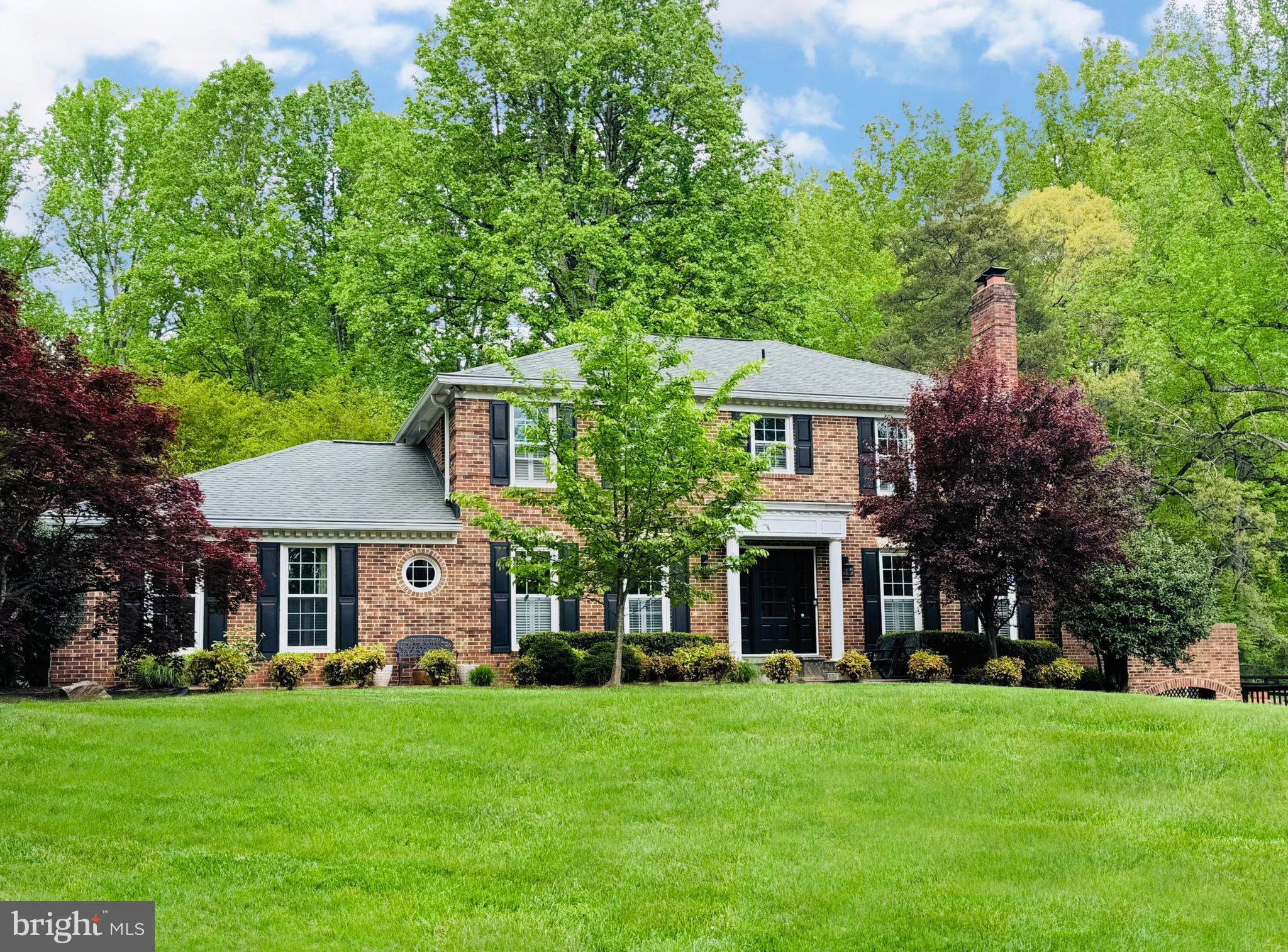 front view of a brick house with a yard