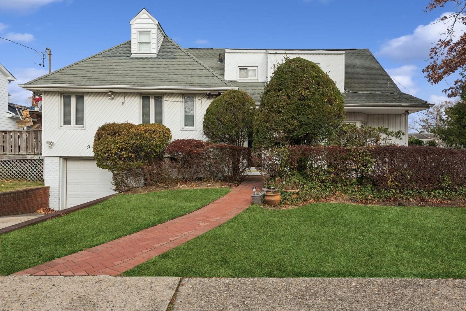 View of front of home featuring a front yard and a garage