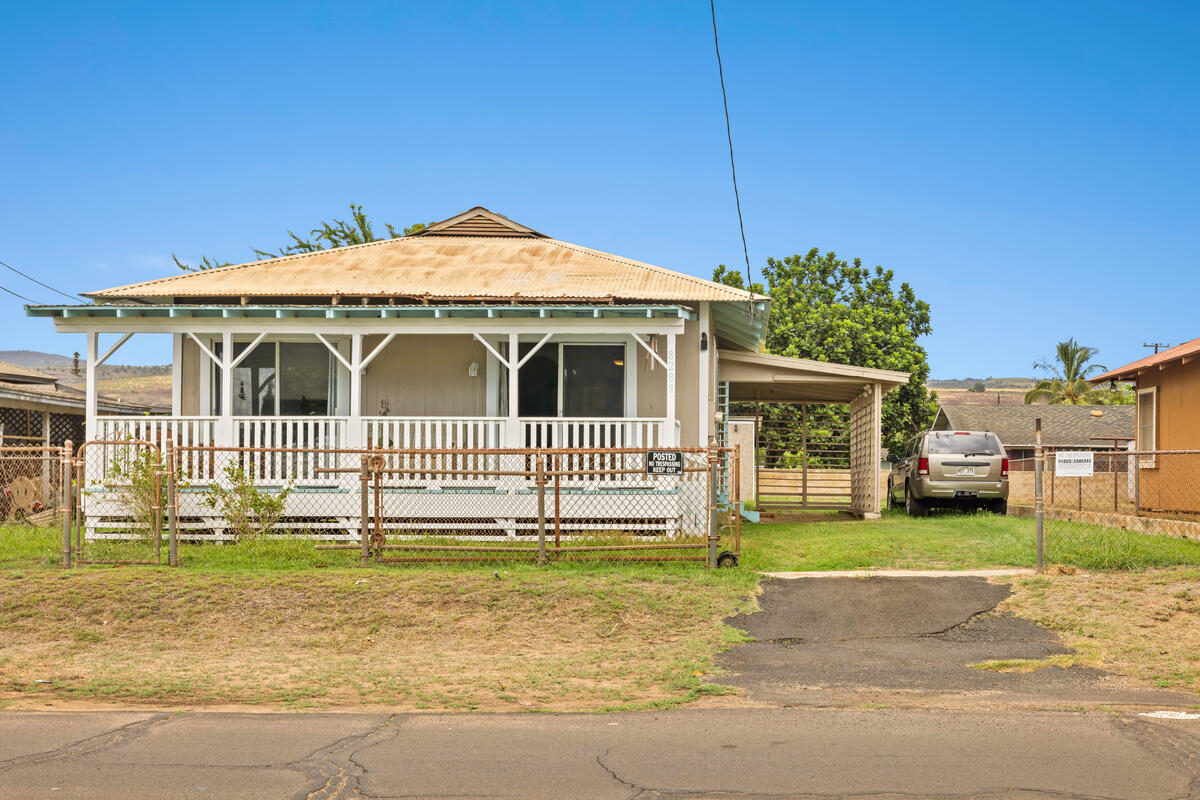 a front view of a house with a garden and plants