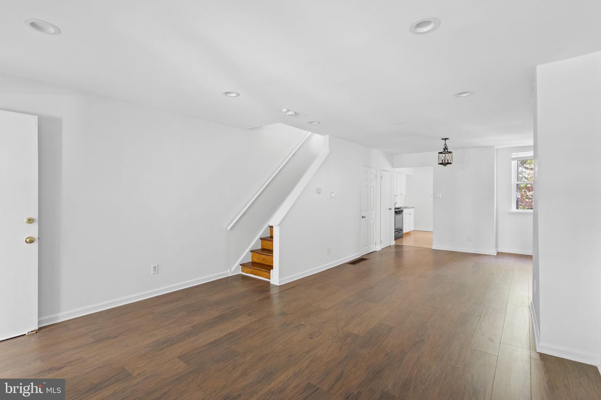 an empty room with wooden floor and white walls