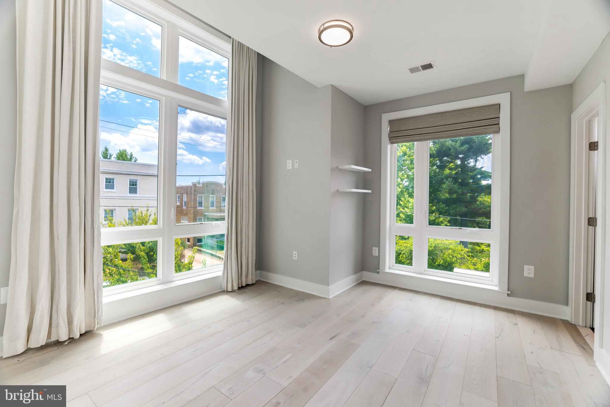 an empty room with large windows and garden view