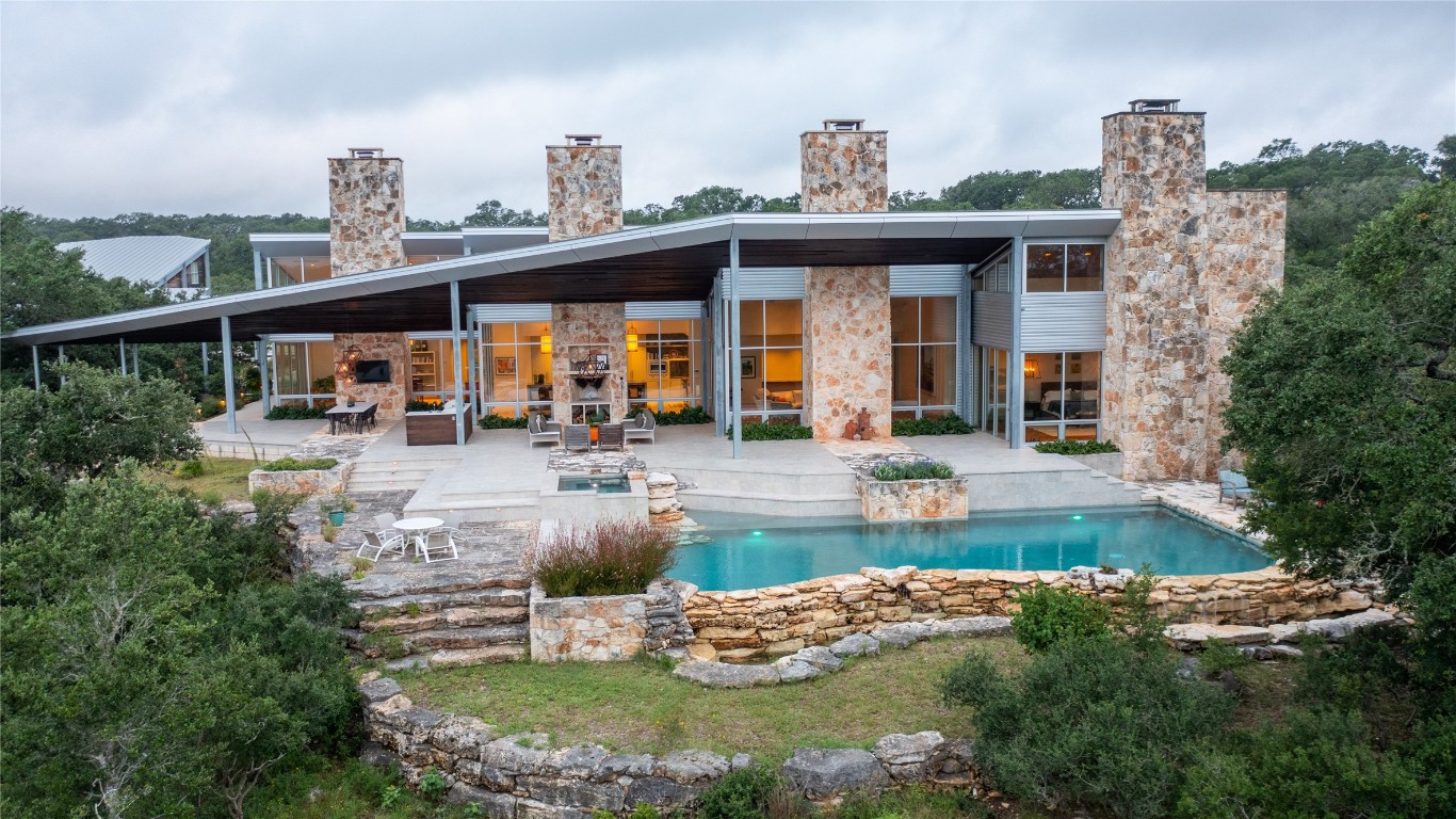 a front view of a house with swimming pool having outdoor seating