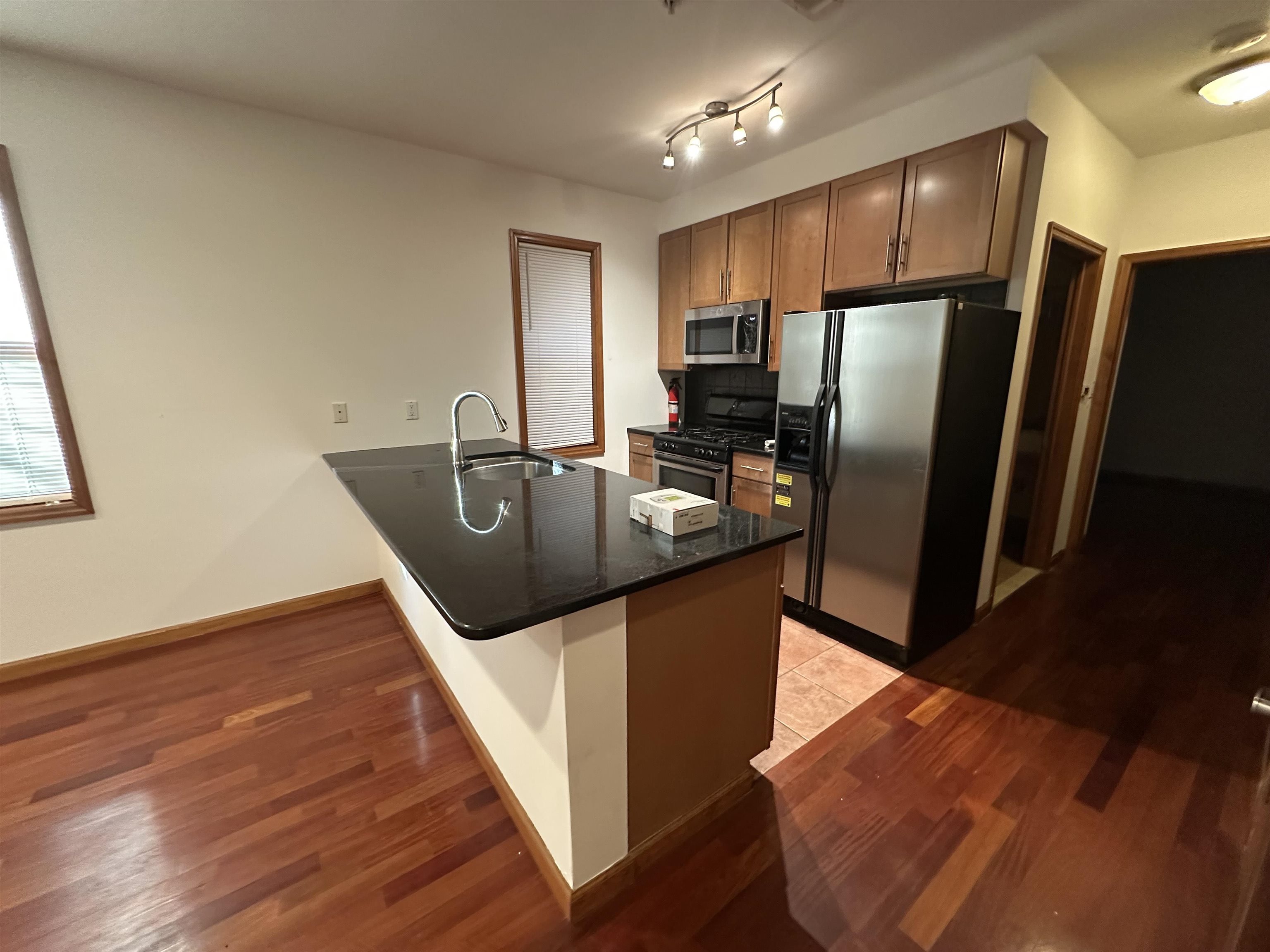 a kitchen with stainless steel appliances granite countertop a refrigerator a sink and a stove