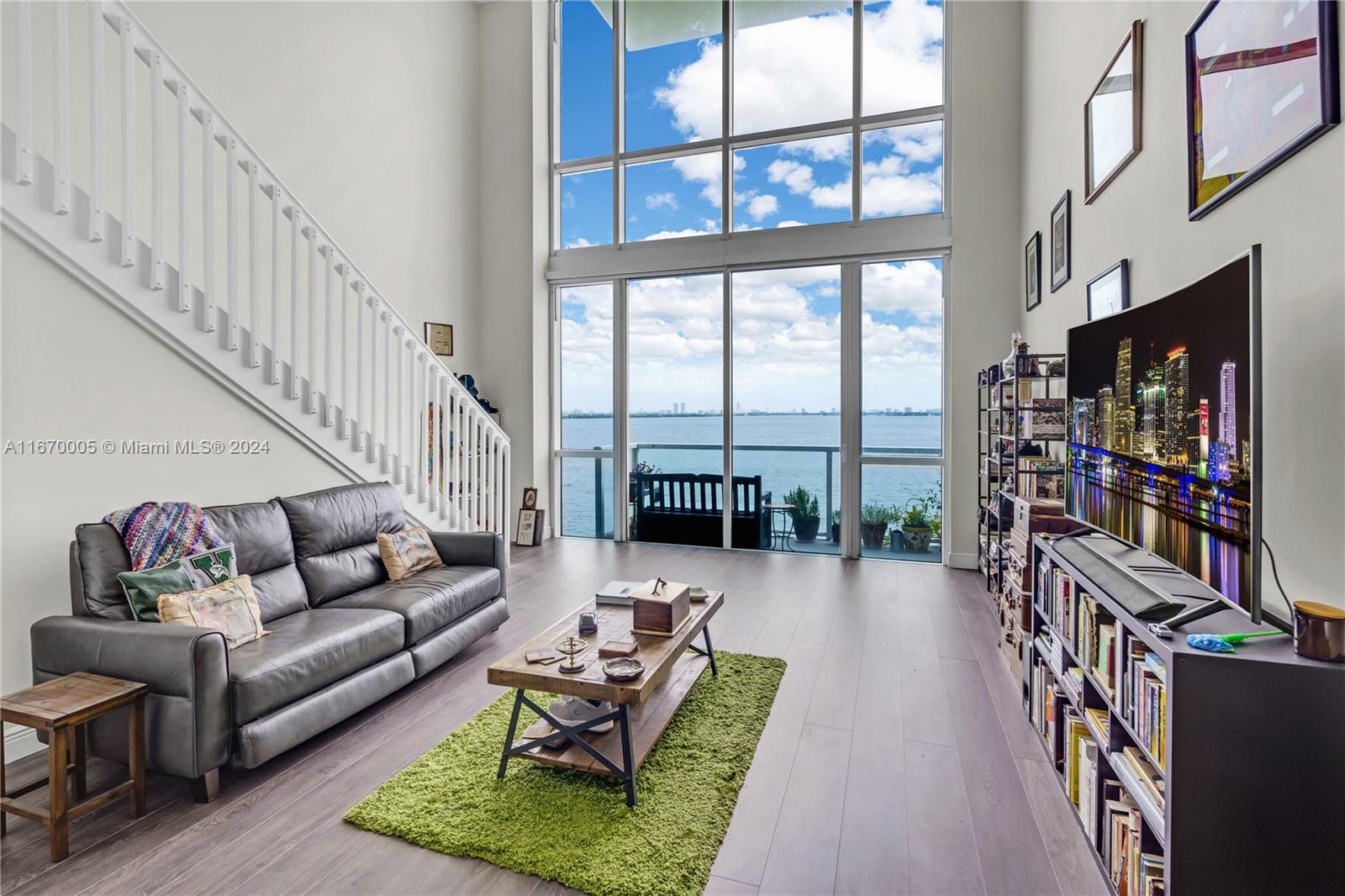 a living room with furniture large bookshelf and a large window