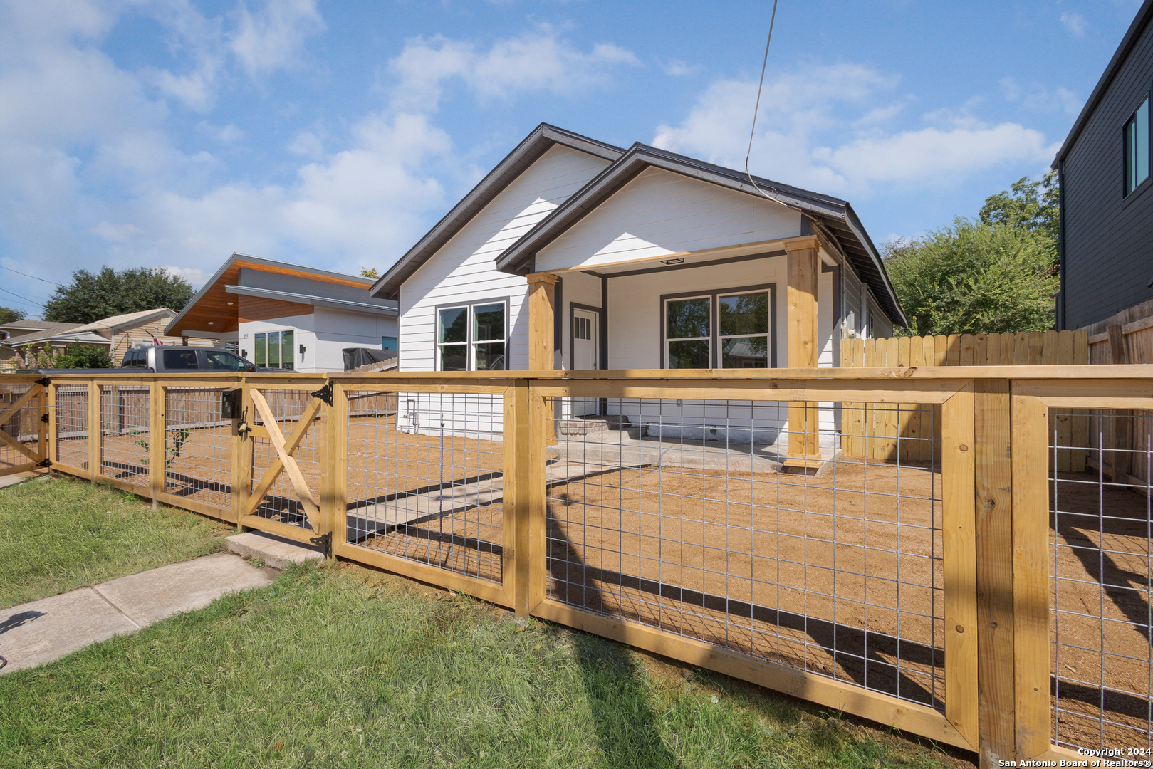 a view of a house with wooden fence