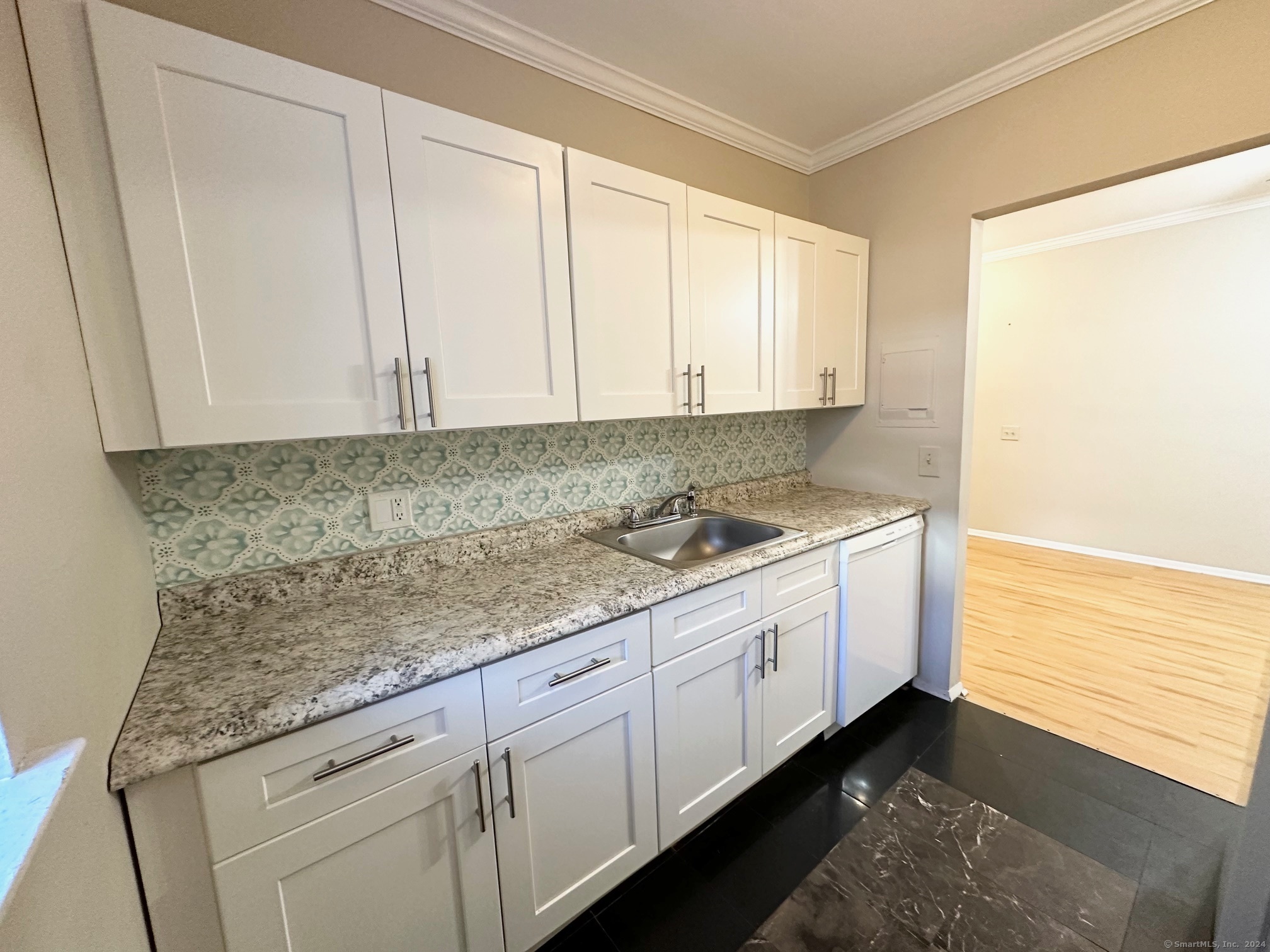 a kitchen with granite countertop white cabinets and sink