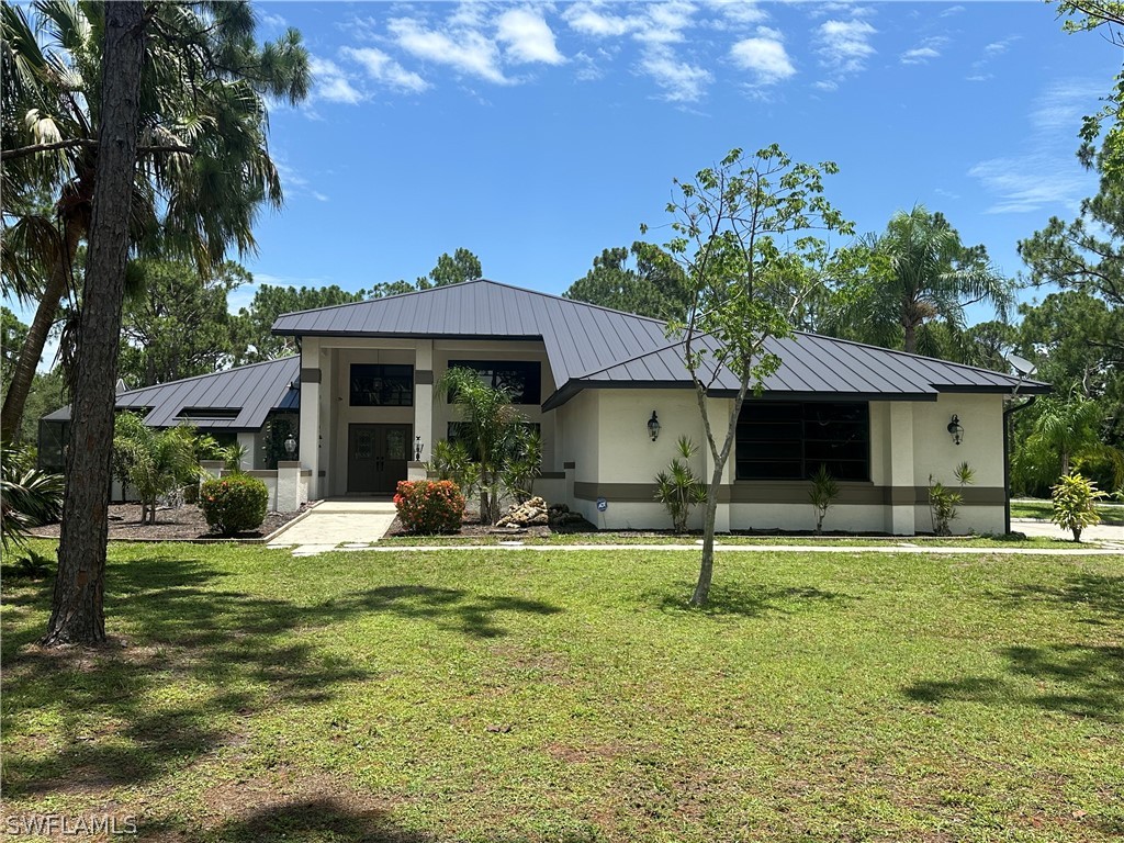 a view of a house with backyard and sitting area