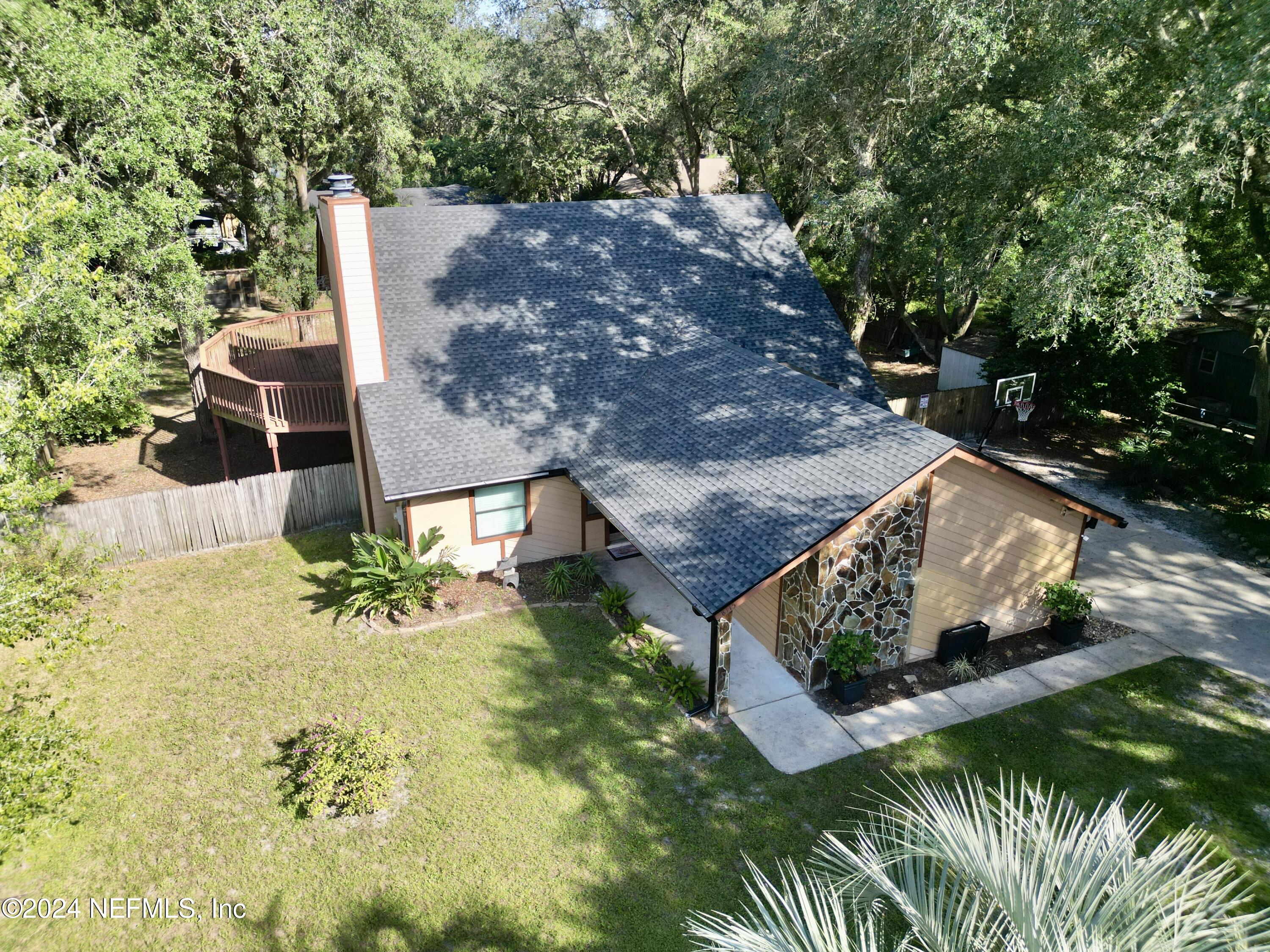 an aerial view of a house with a yard and large tree