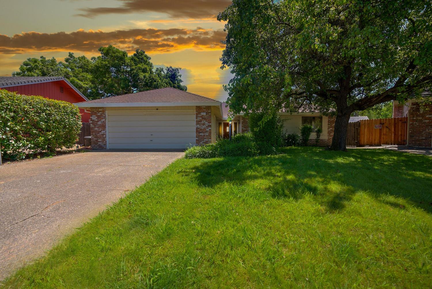 a front view of a house with yard and green space