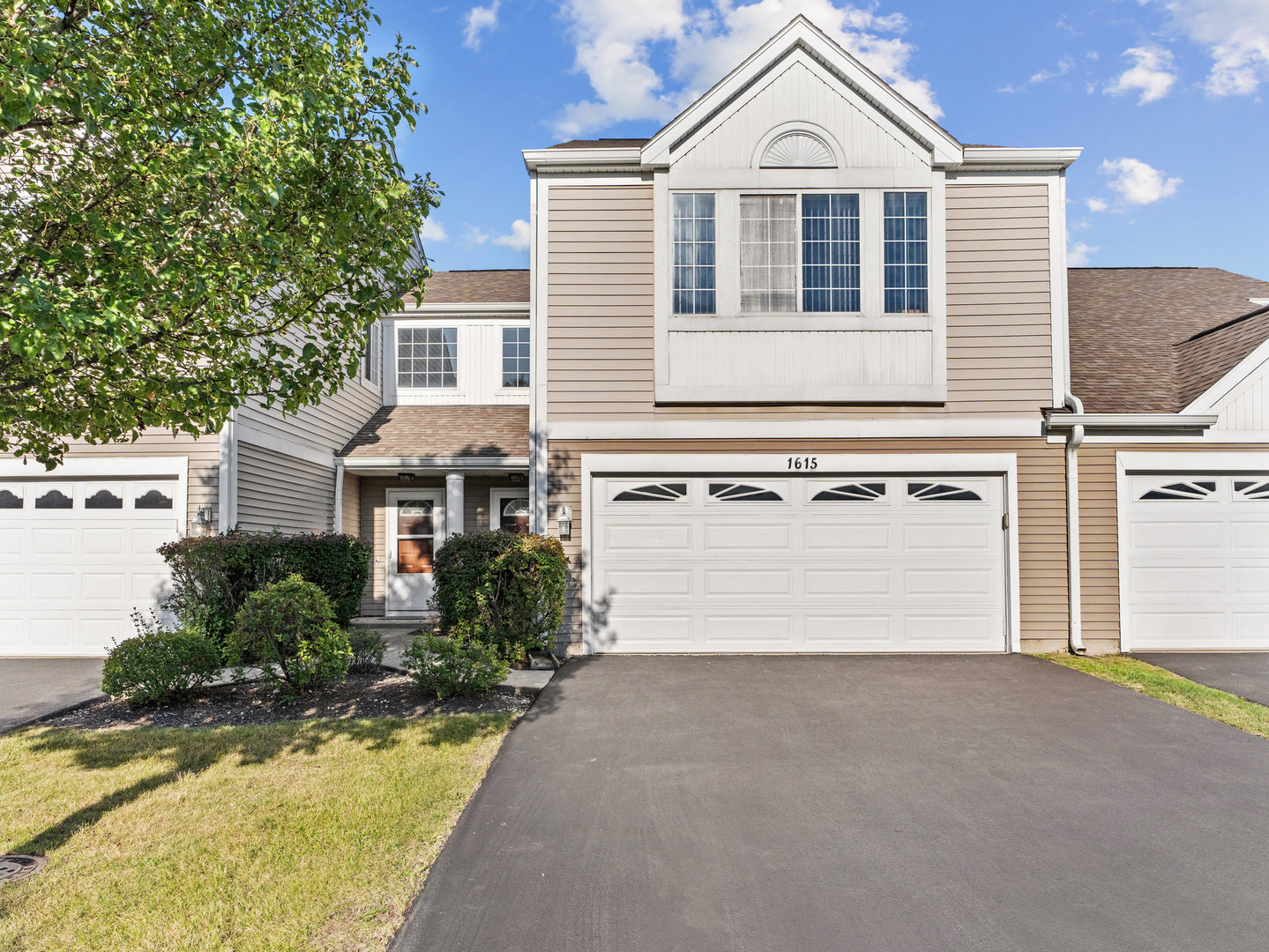 a front view of a house with a yard and garage