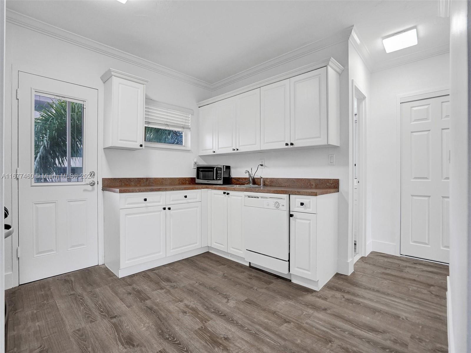 a kitchen with granite countertop white cabinets and white appliances