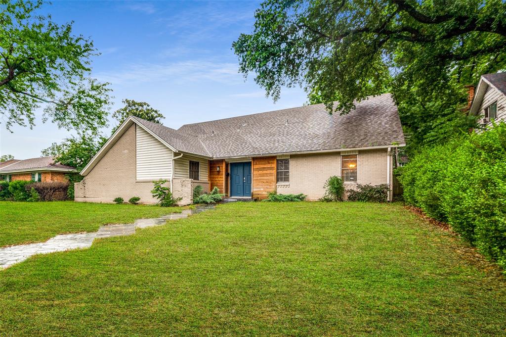 a front view of house with yard and trees