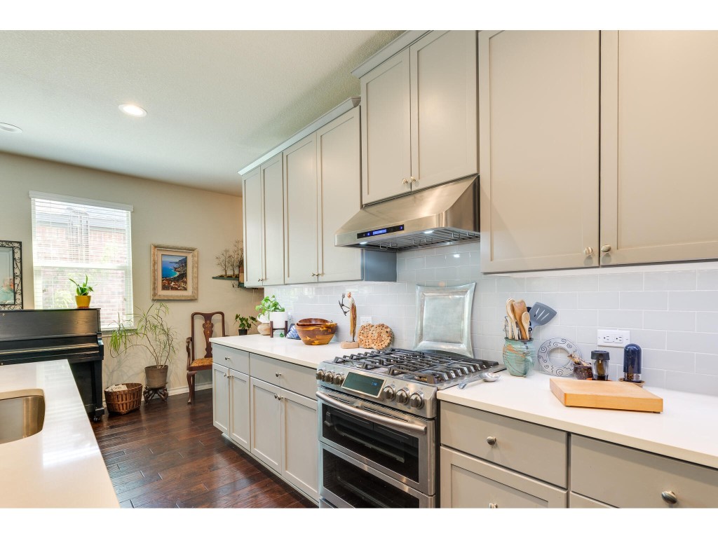 a kitchen with stainless steel appliances granite countertop a sink stove and cabinets