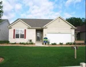 a front view of a house with a garden and yard