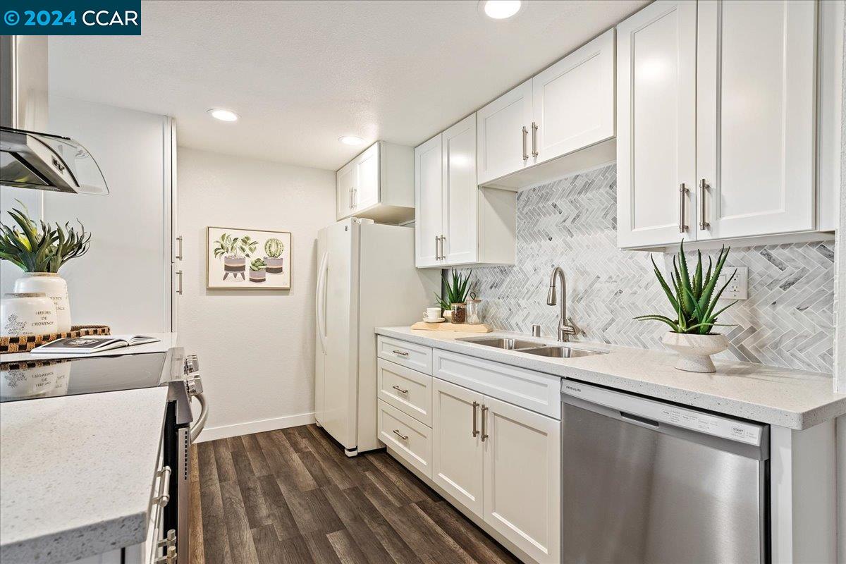 a kitchen with stainless steel appliances a sink a stove a refrigerator and cabinets