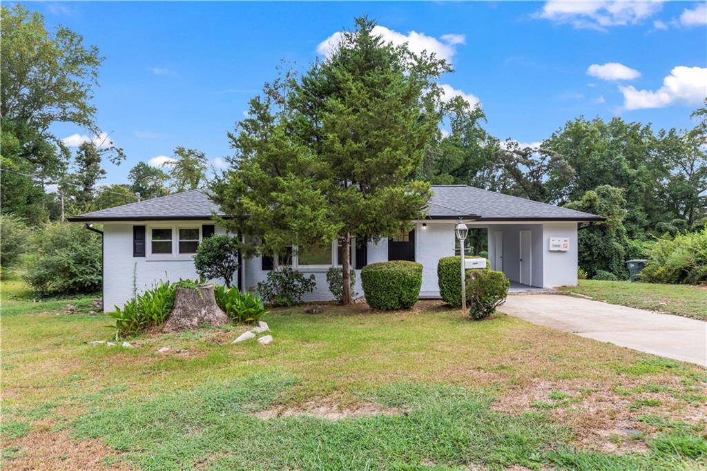 a front view of a house with a yard and trees