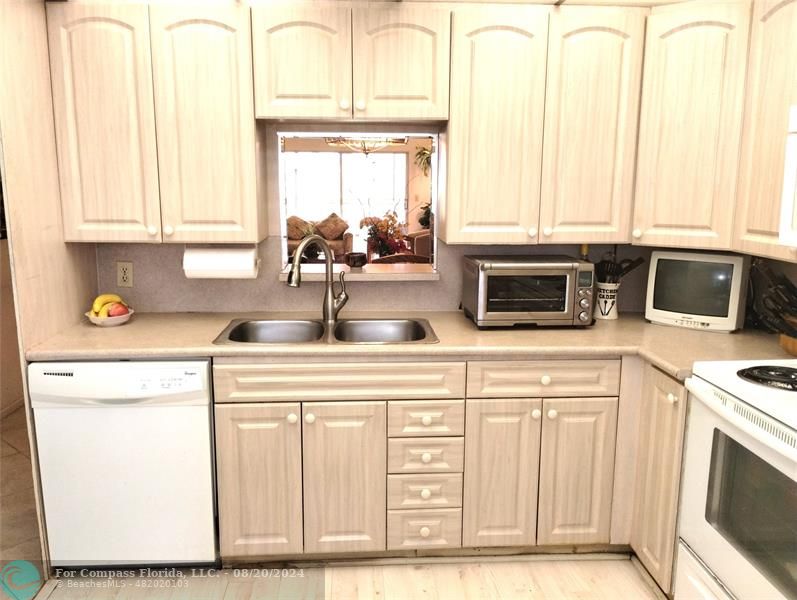 a kitchen with stainless steel appliances a sink a stove and white cabinets