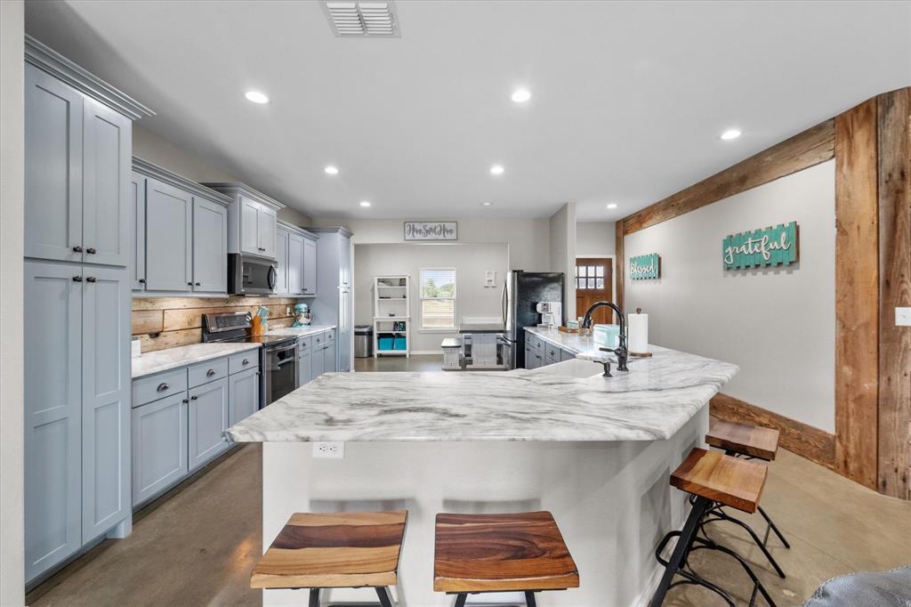 a large kitchen with kitchen island a dining table and chairs