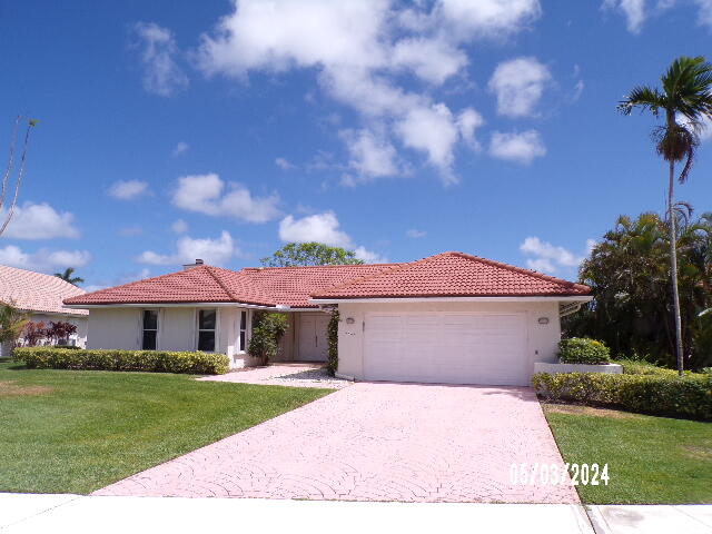 a front view of a house with a garden and yard