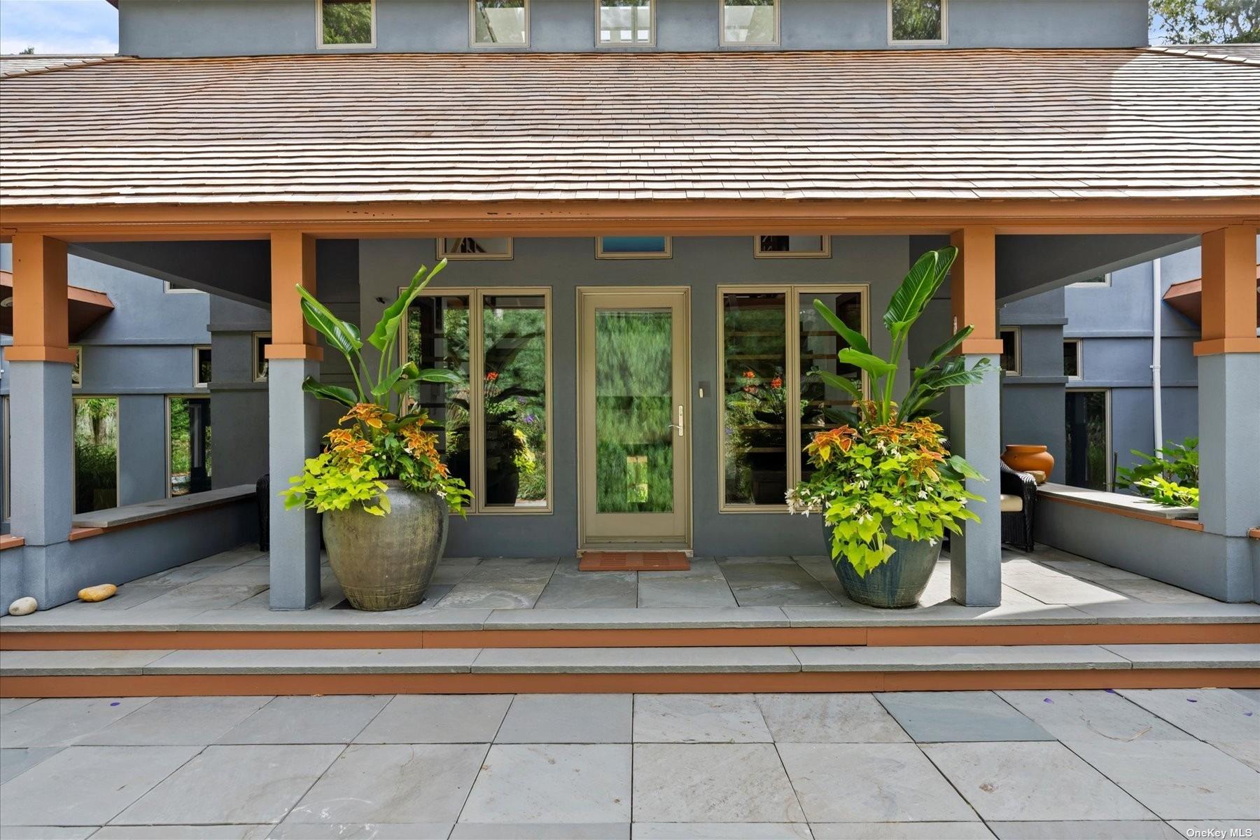 a front view of a house with potted plants