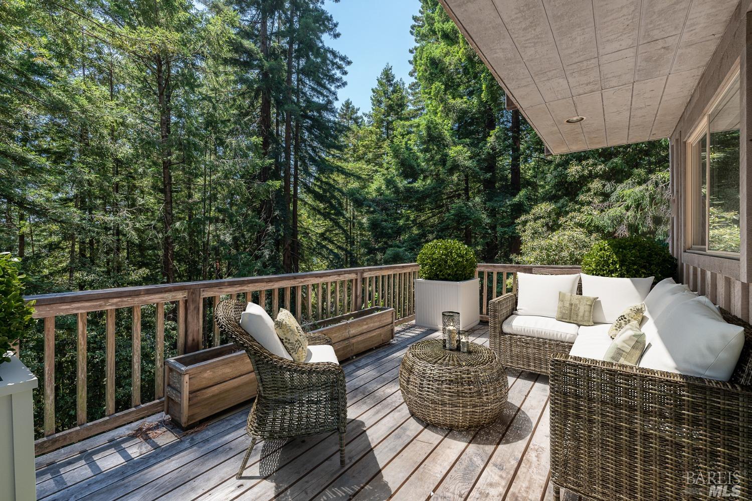 a roof deck with couches and wooden floor