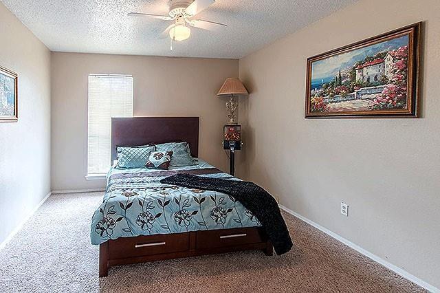 a bedroom with a bed and a painting on the wall