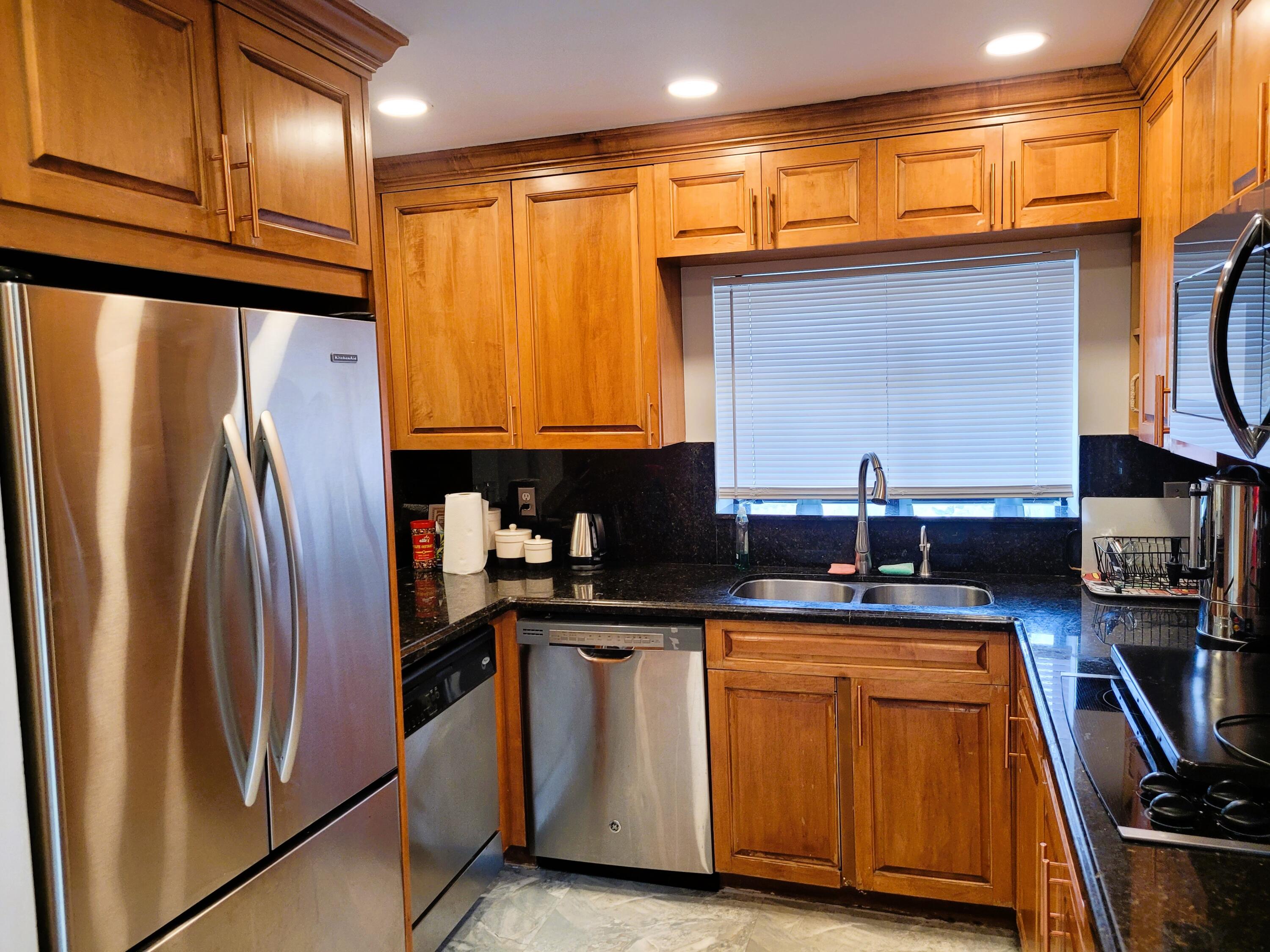 a kitchen with stainless steel appliances granite countertop a refrigerator and a stove