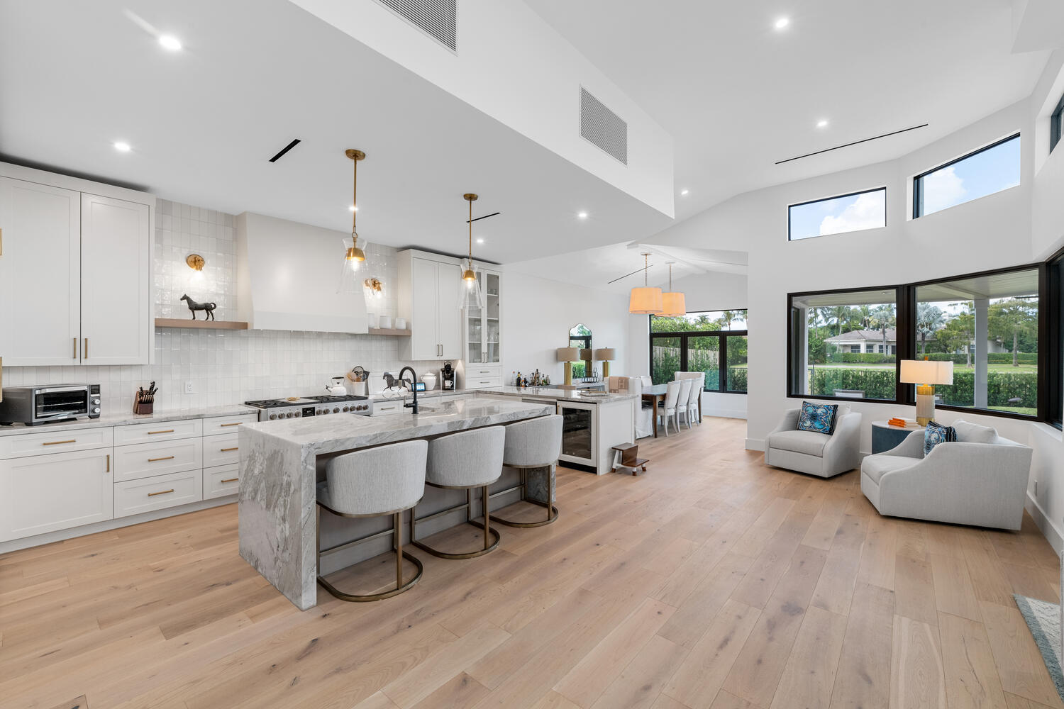 a large white kitchen with lots of counter space dining table and chairs