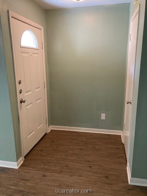 an empty room with wooden floor and mirror