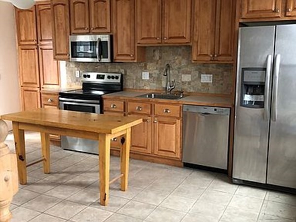 a kitchen with stainless steel appliances granite countertop a stove a refrigerator and a microwave