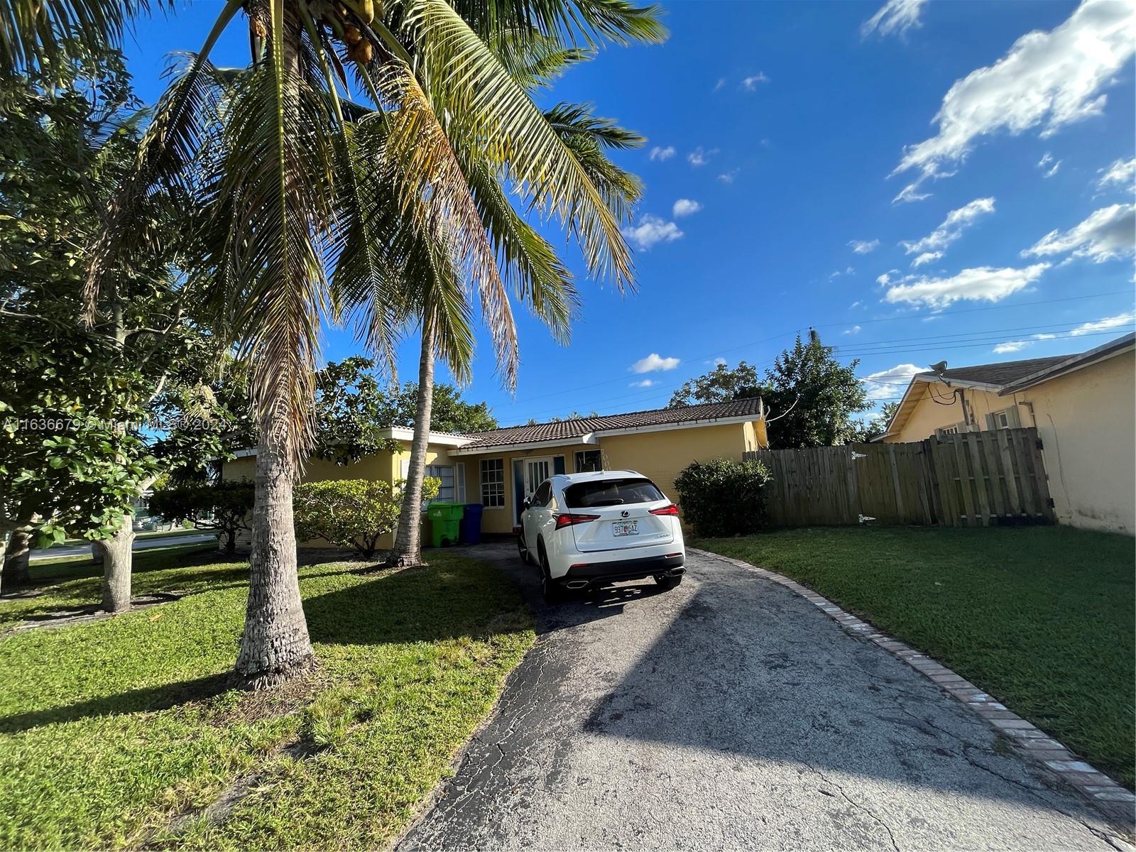 a car parked in front of a house with a yard