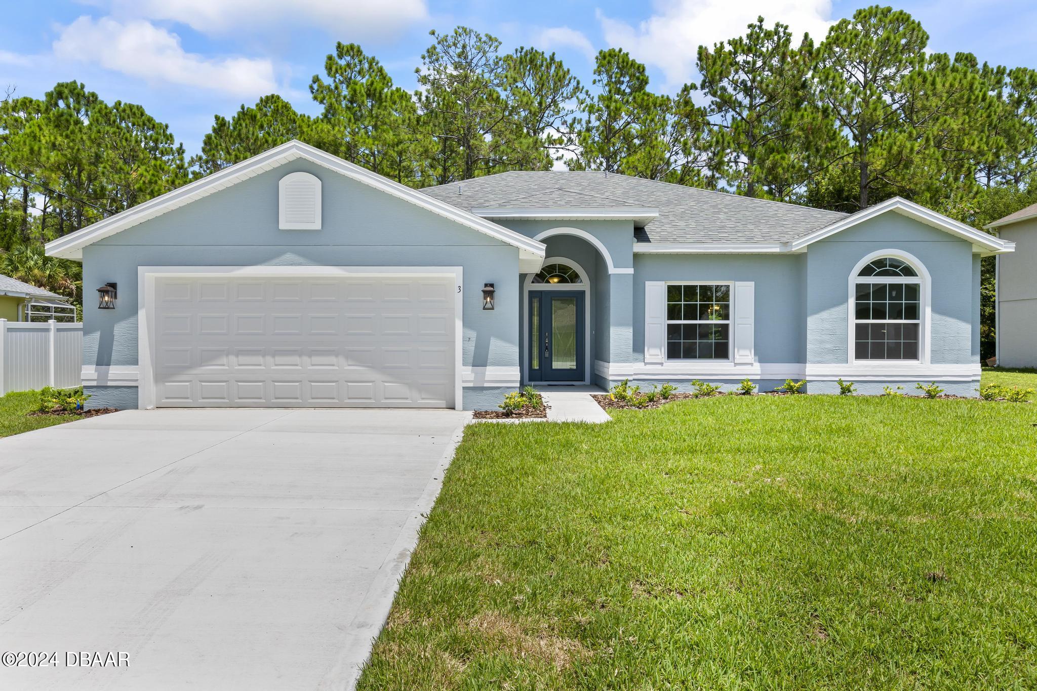 a front view of a house with yard and green space