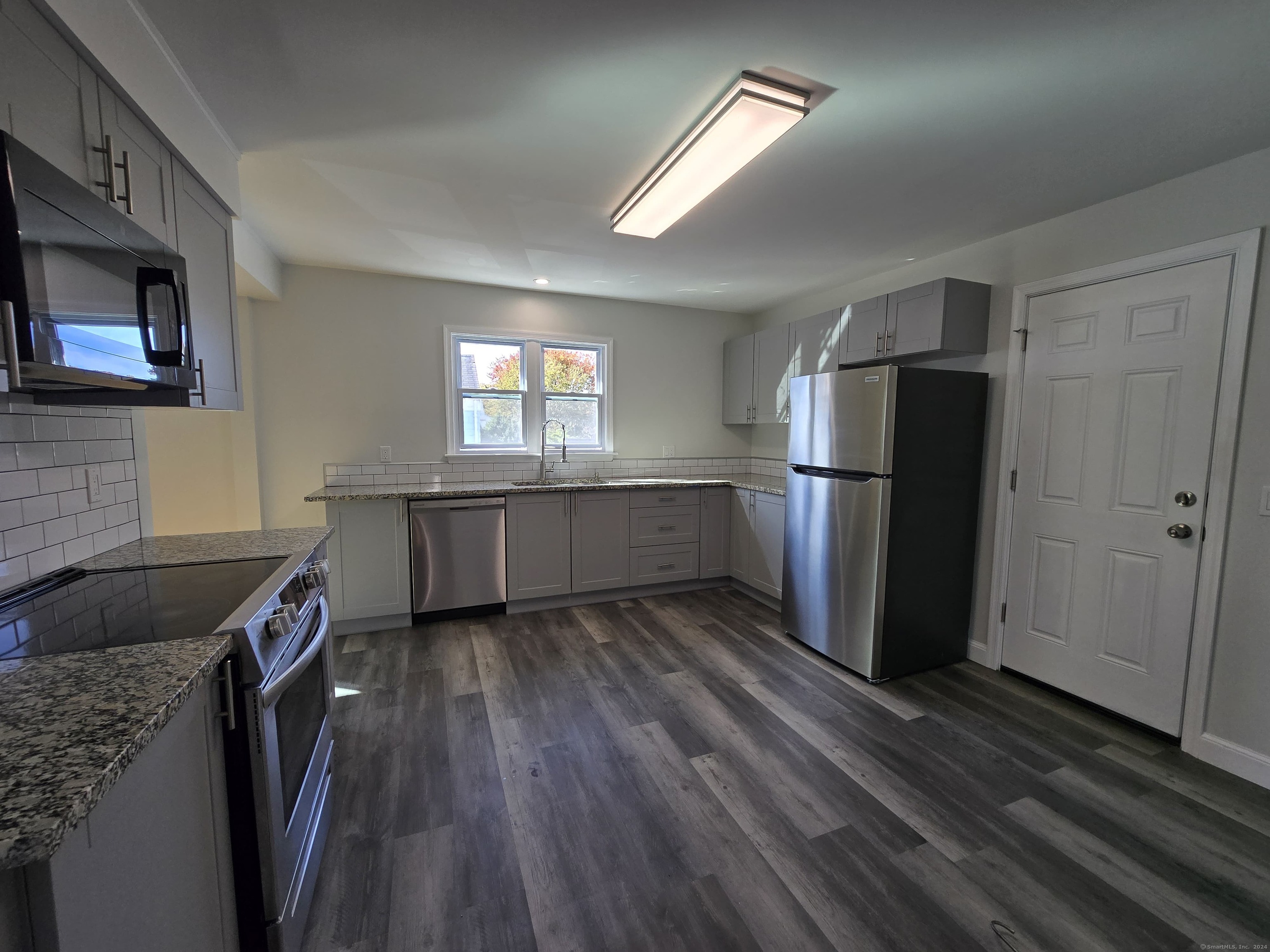 a kitchen with a refrigerator and a stove top oven