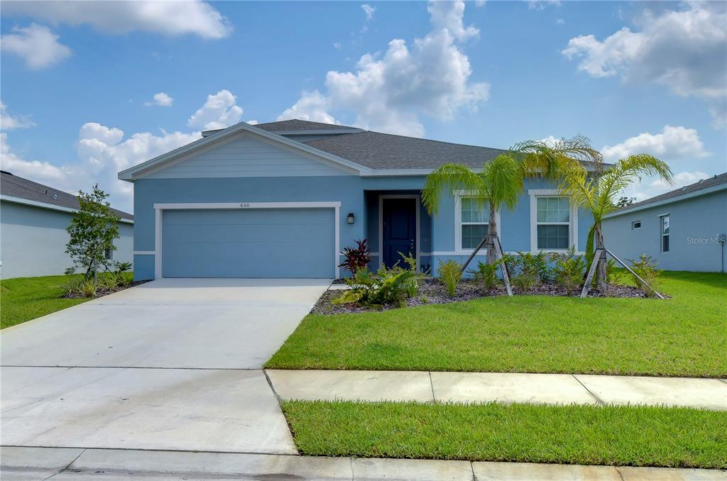 a front view of a house with a yard and garage