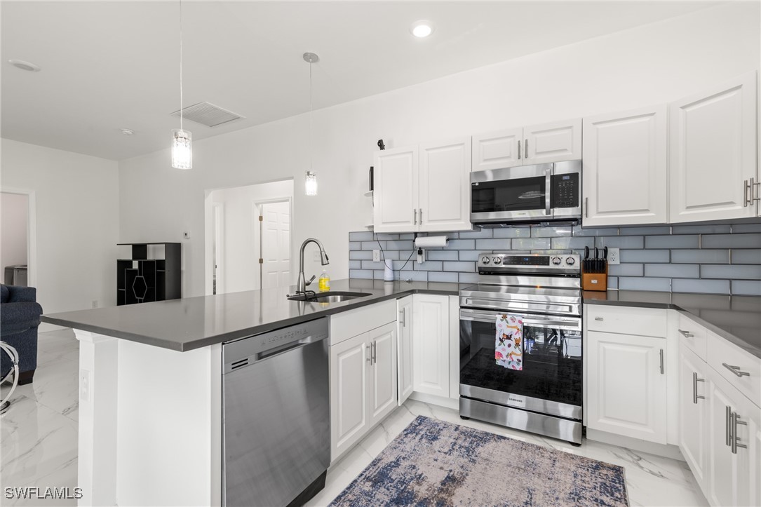 a kitchen with stainless steel appliances granite countertop a sink stove and microwave