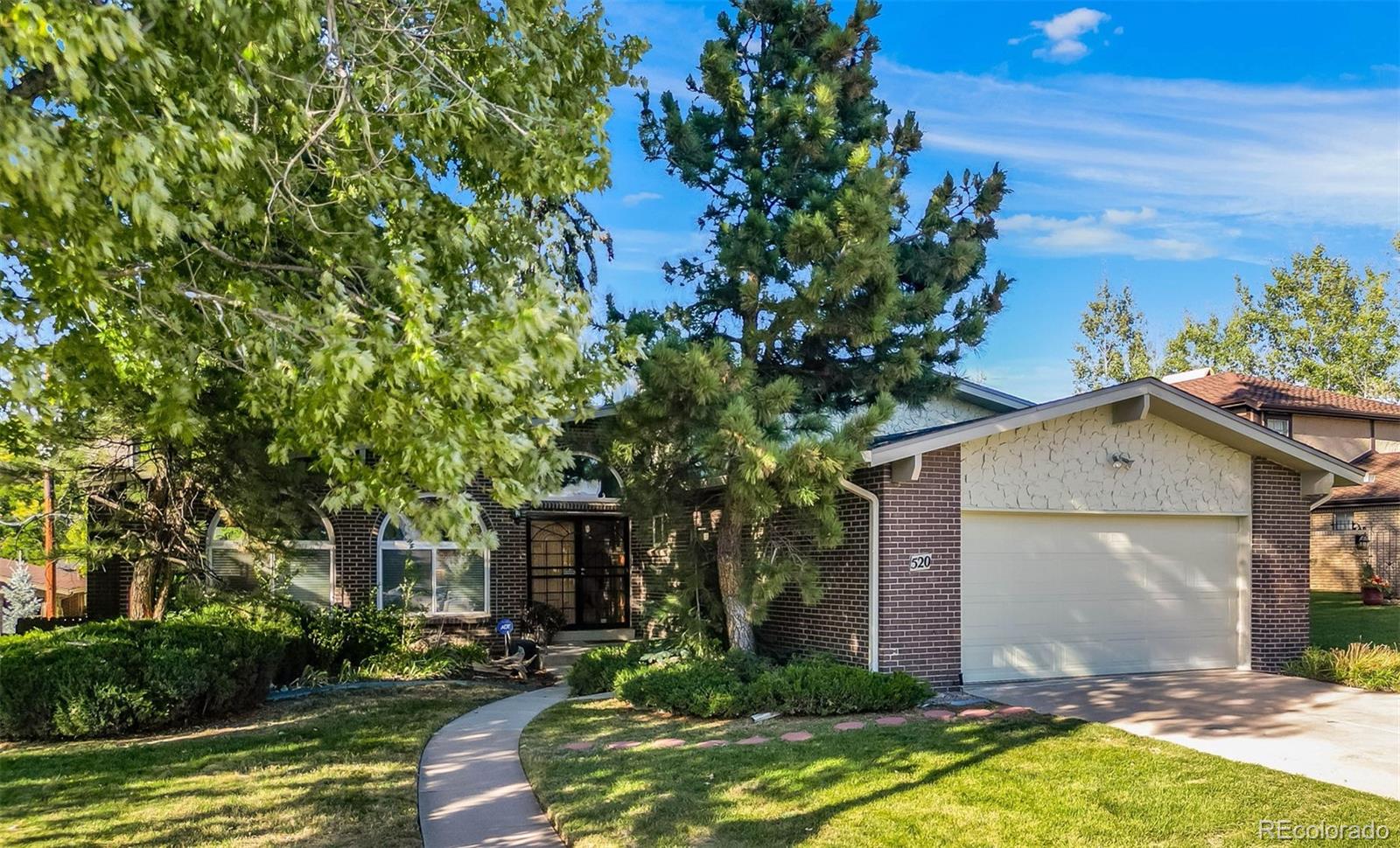 a front view of a house with a yard garage and outdoor seating